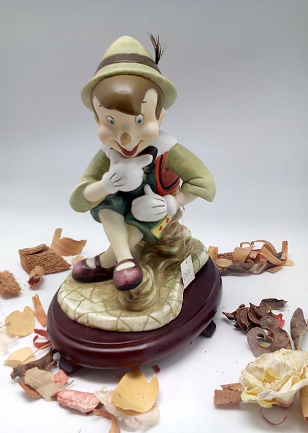 Figura de Pinocho de cerámica sobre centros de mesa con base de madera de cerezo #9D6736