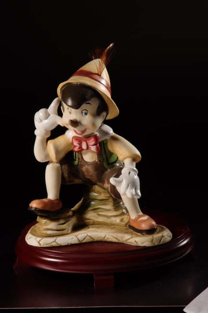 Figurilla de Pinocho de cerámica sobre centros de mesa con base de madera de cerezo #9D6737