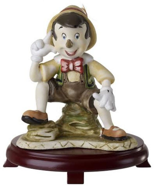 Figurilla de Pinocho de cerámica sobre centros de mesa con base de madera de cerezo #9D6737