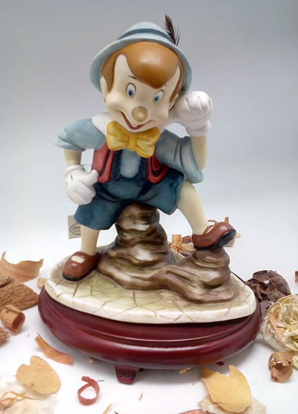 Figura de Pinocho de cerámica sobre centros de mesa con base de madera de cerezo #9D6734